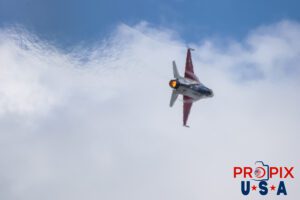 How's my flying: 1 (800) BLEW BY U. F-16 Falcon Demonstrator Aircraft, piloted by Major Taylor "FEMA" Hiester performing a high speed knife edge banking turn with afterburner engaged. The image appears to be out of focus, but the picture is actually looking through the immensely hot exhaust gases, which is causing the blurriness. The forming of contrails visible near the wings fuselage attachment points and the contrail visible from the left wing are indicative of the agressiveness and ferocity of the maneuver. This was part of the F-16 performance at the 2025 Sun N Fun airshow in Lakeland Florida. Aircraft code: F16 Airport Code(s): KLAL, LAL