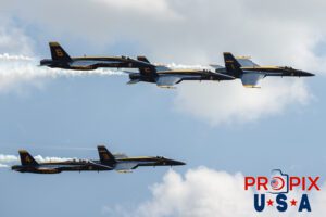 Although only five of the Blue Angels squeezed into this picture, all six were actually performing the "Delta Aileron Roll". #5 not pictured. #1 Commander Adam Bryan (Commanding Officer) #2 Commander Jack Keilty (Right Wing) #3 Major Brandon Wilkins (Left Wing) #4 Lieutenant Commander Wes Perkins (Slot) #5 Commander Thomas Zimmerman (Lead Solo) #6 Lieutenant Commander Connor O'Donnell (opposing Solo) Aircraft code: F18 Airport code(s): KAGS, AGS
