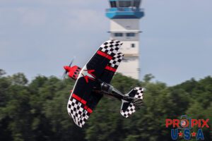 Skip Stewart performs a low altitude knife edge pass in front of the control tower in his 2011 Pitts S-2 aircraft at the Sun N Fun airshow in Lakeland Florida. Aircraft code: PTS2 Airport code(s): KLAL, LAL