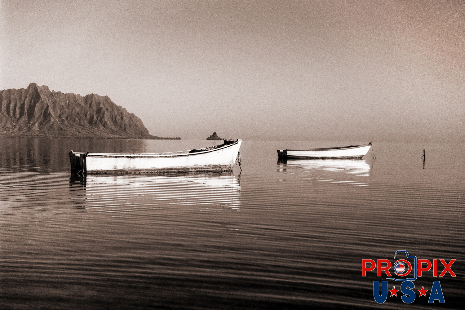 Chinaman Boats. This image is of two boats moored in the shallow waters North of Kaneohe Hawaii with Chinamans hat island in the background. This photo was taken in the 1990's with a film camera.