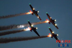 Aeroshell Team performing with their T-6 Texans during the night airshow at the 2017 Sun N Fun event in Lakeland Florida. Aircraft code AT6.