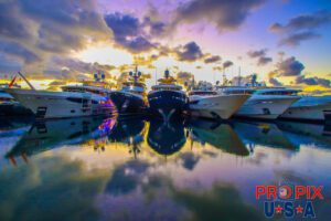 Megayachts docked side by side at sunrise.