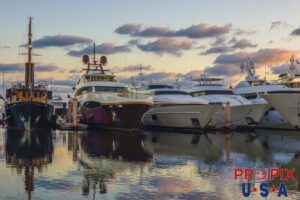Yachts docked at a marina during a beautiful sunrise.