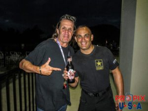 Nicko McBrain of Iron Maiden giving NHRA 8x Top Fuel World champion Tony Schumacher a cold "Trooper" beer after a long day at the race track.